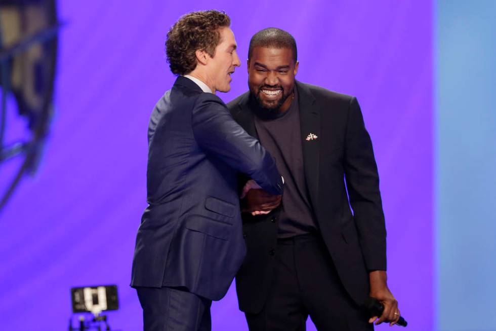 Rapper Kanye West, right, shakes hands with Joel Osteen during a service at Lakewood Church, S ...