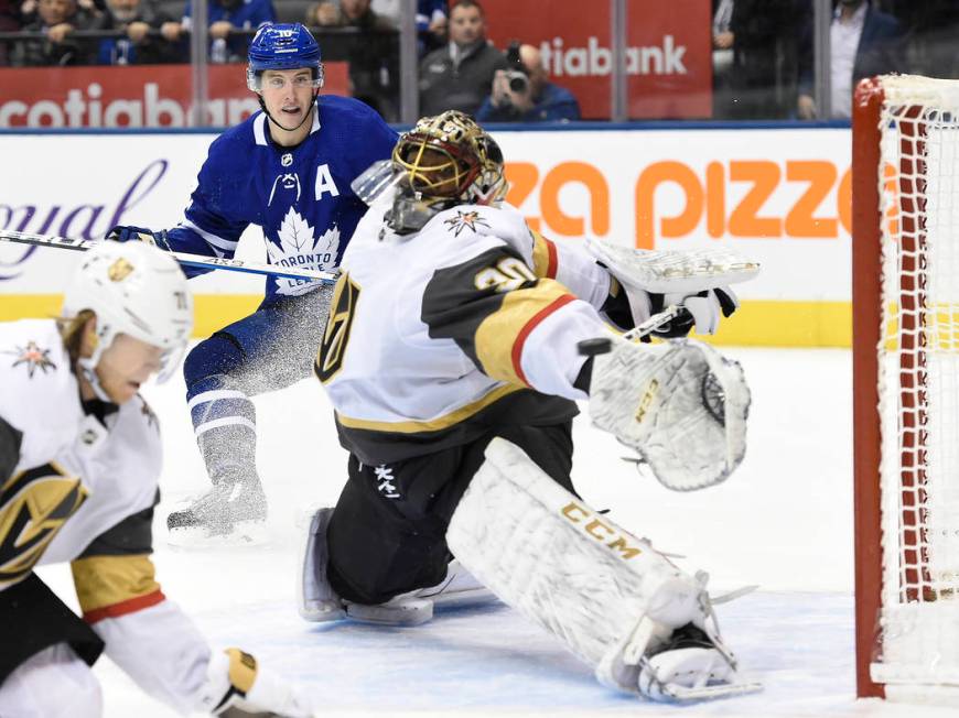 Toronto Maple Leafs center Mitchell Marner, back, watches as a goal by center John Tavares, goe ...