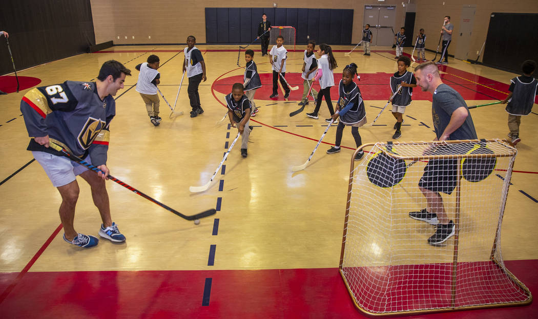 Vegas Golden Knights forward Max Pacioretty, left, plays street hockey with kids at the Doc Pea ...