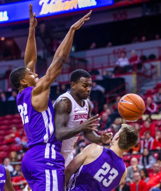 UNLV Rebels guard Amauri Hardy (3, center) is fouled on the drive by Abilene Christian Wildcats ...