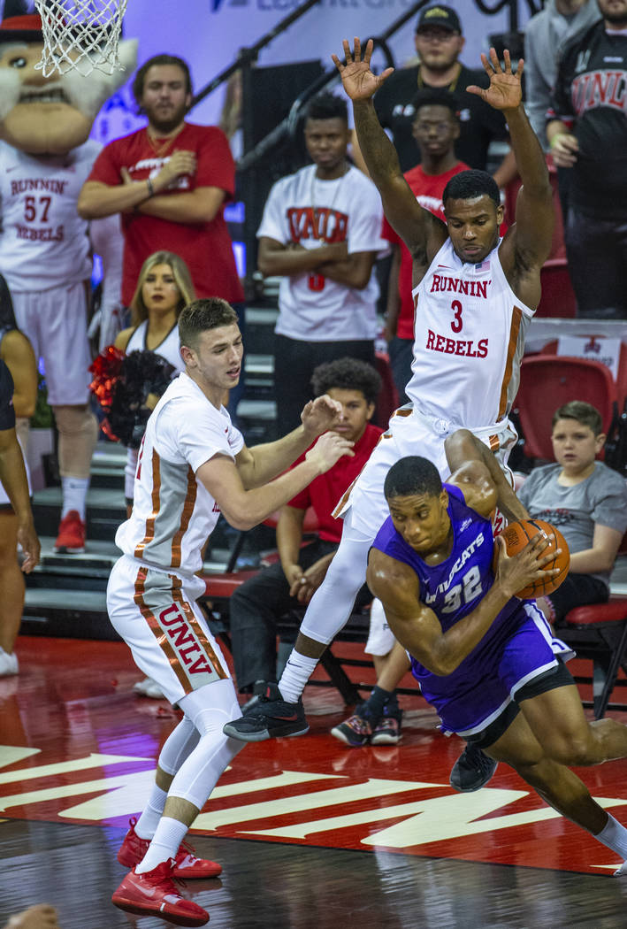 UNLV Rebels forward Vitaliy Shibel (22, left) and teammate guard Amauri Hardy (3, top right) d ...