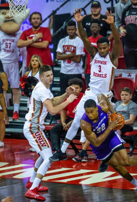 UNLV Rebels forward Vitaliy Shibel (22, left) and teammate guard Amauri Hardy (3, top right) d ...