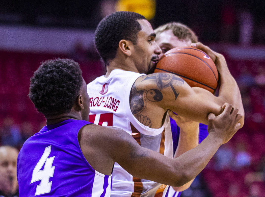 UNLV Rebels guard Elijah Mitrou-Long (55, center) secures the ball from Abilene Christian Wildc ...