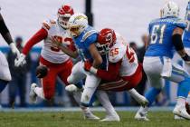 Los Angeles Chargers quarterback Philip Rivers, center, is sacked by Kansas City Chiefs defensi ...