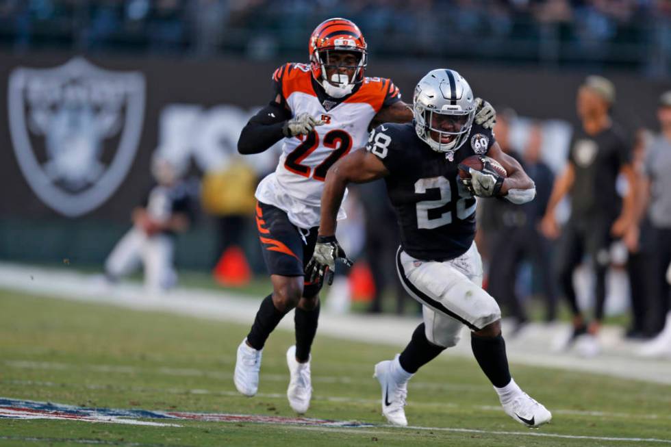 Oakland Raiders running back Josh Jacobs runs with the ball past Cincinnati Bengals cornerback ...