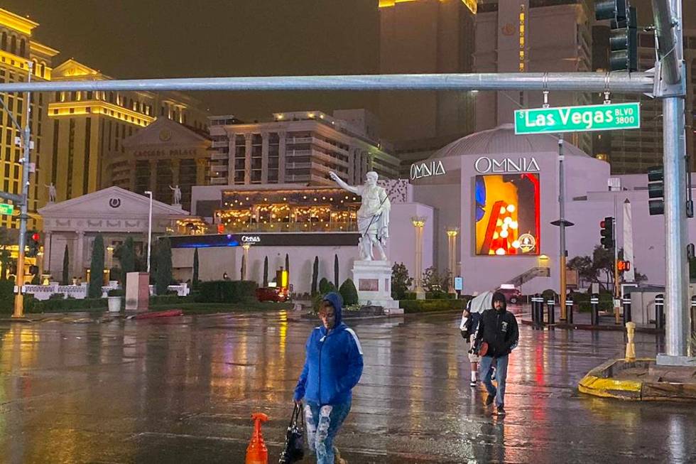 Pedestrians cross the Las Vegas Strip near Caesars Palace in the rain, Wednesday, Nov. 20, 2019 ...