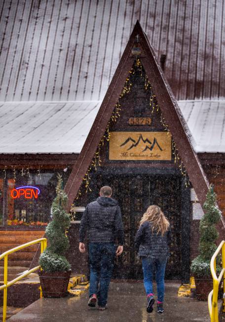 A couple walks through snow outside Mt. Charleston Lodge on Wednesday, Nov. 20, 2019. (L.E. Bas ...