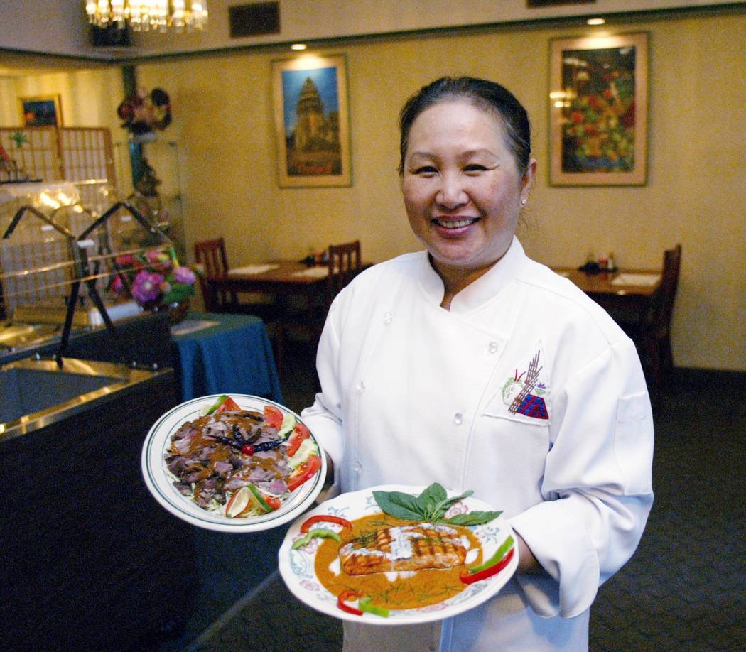 Chef Saipin Chutinia displays a Left, Nua Suo Renu (Beef Tamarind sauce) and Salmon Panang (cur ...