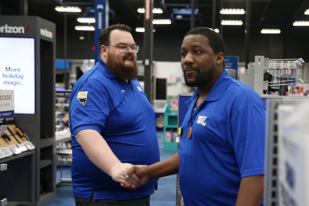 Sales manager Michael Isbell, left, shakes hands with sales consultant T.J. Gardner during a tr ...
