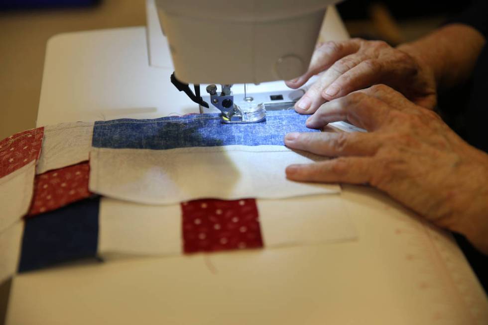 Brenda Graf stitches a pattern for a quilt during a meet by the Quilters for Veterans to make p ...
