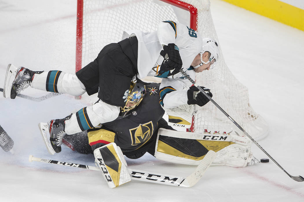 San Jose Sharks center Logan Couture (39) collides with Vegas Golden Knights goaltender Marc-An ...