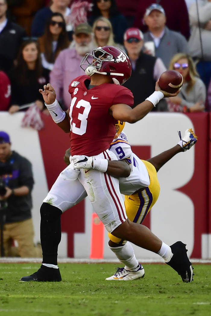 Alabama quarterback Tua Tagovailoa (13) is hit by LSU safety Marcel Brooks (9) as he throws a p ...