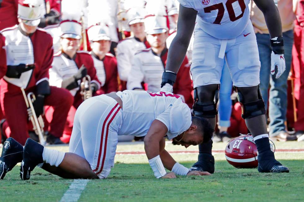 Alabama sive lineman Alex Leatherwood (70) checks on quarterback Tua Tagovailoa (13) after he w ...