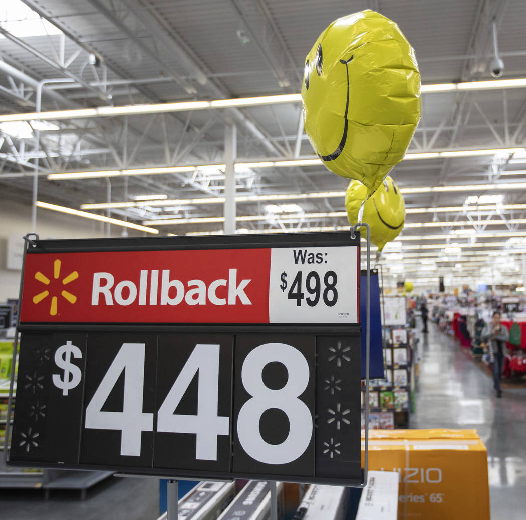 Signs marking holiday sales are distributed throughout Walmart on Blue Diamond Road on Friday, ...