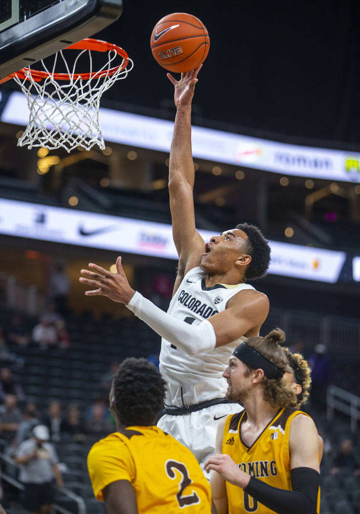 Colorado guard Tyler Bey (1) gets over the Wyoming defense for a basket during the first half o ...