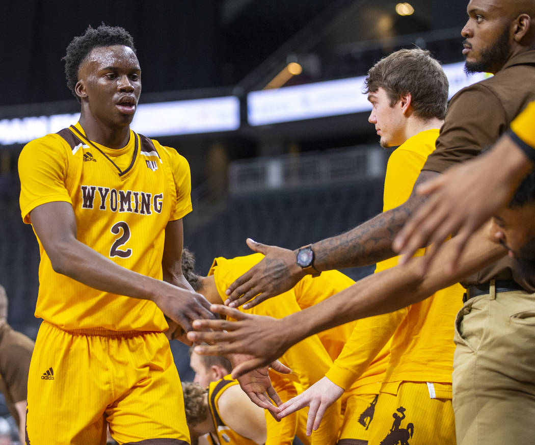 Wyoming guard A.J. Banks (2) gets some encouragement from teammates on the bench versus Colorad ...