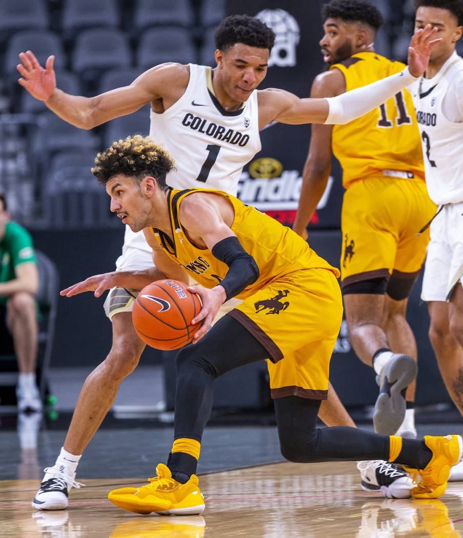 Colorado guard Tyler Bey (1, above) defends the lane over Wyoming guard Hunter Maldonado (24) d ...