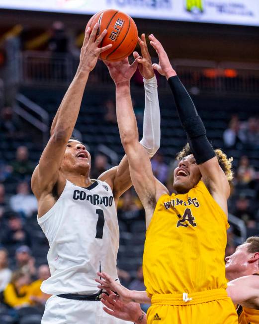 Colorado guard Tyler Bey (1, left) battles for a loose ball with Wyoming guard Hunter Maldonado ...