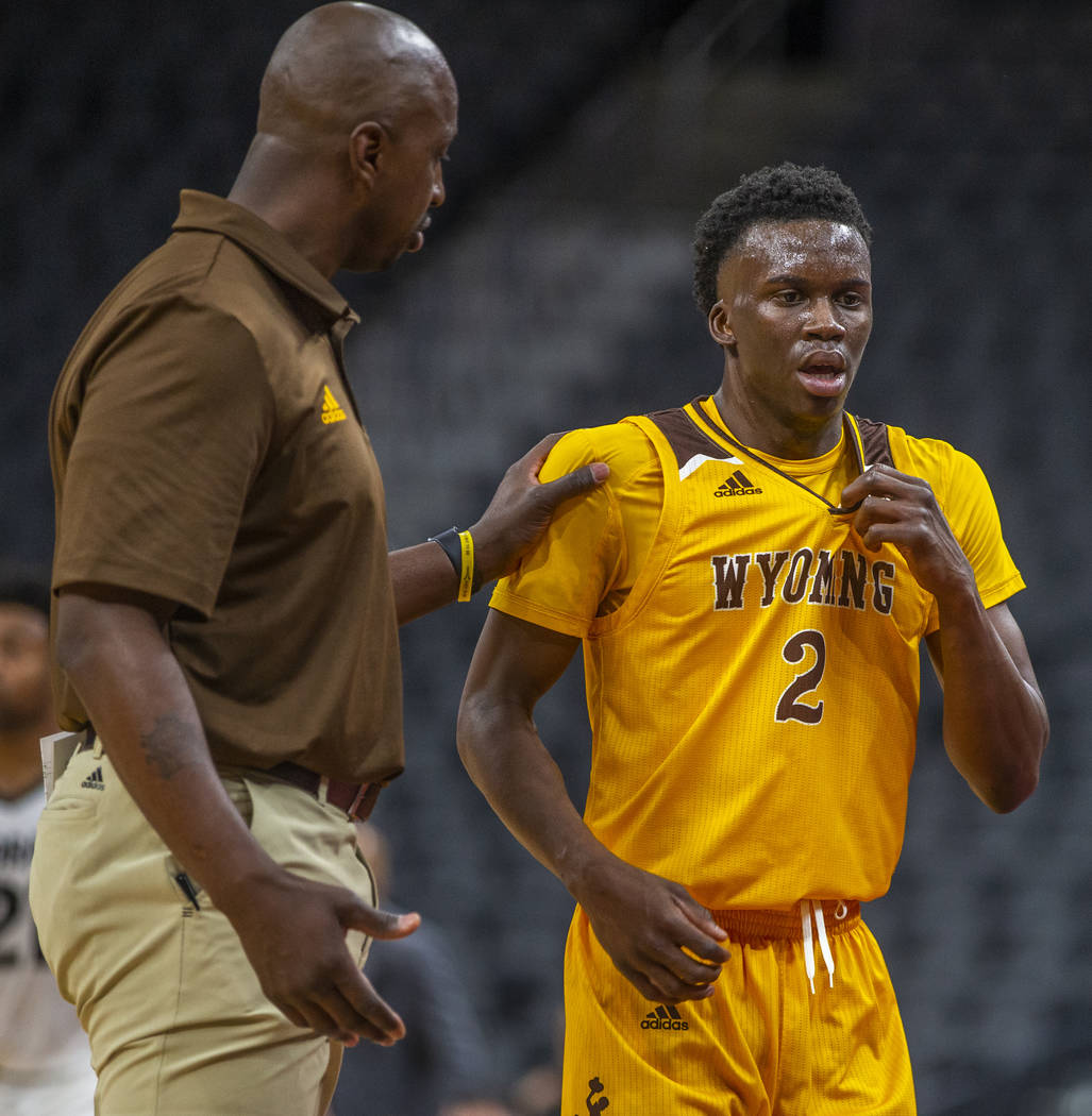 Wyoming head coach Tad Boyle, left, counsels guard A.J. Banks (2) while battling Wyoming during ...