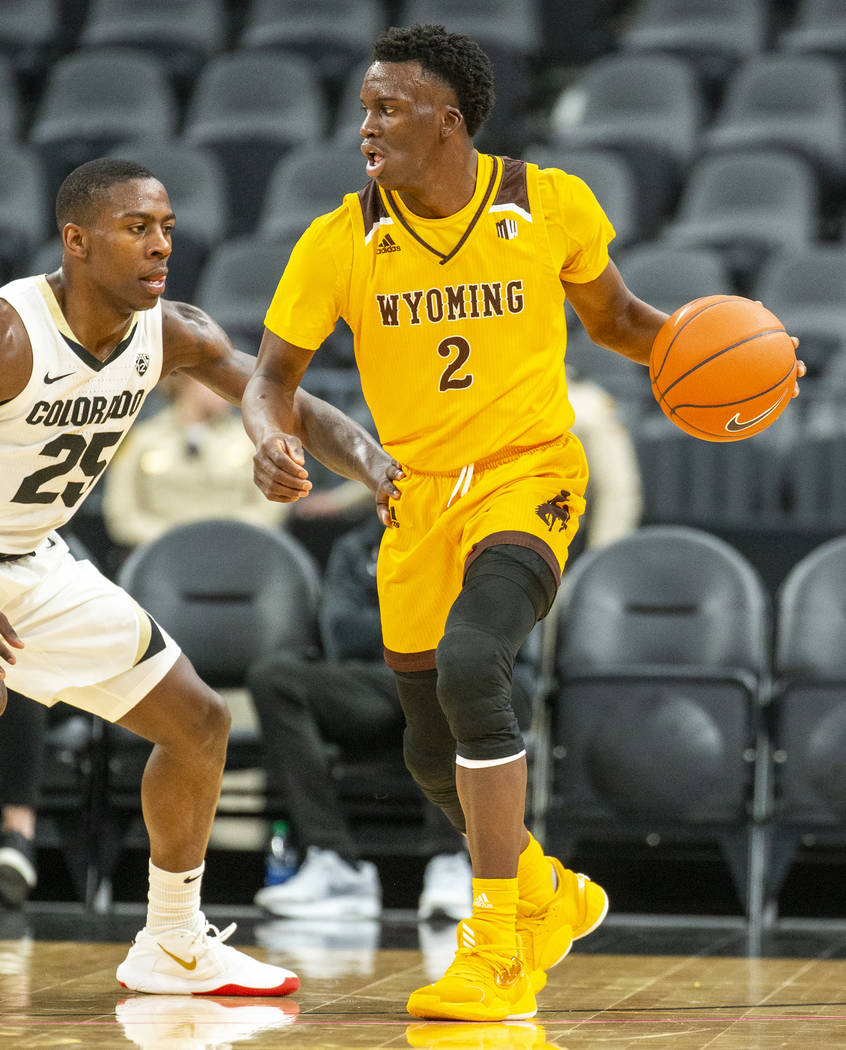Wyoming guard A.J. Banks (2, right) looks to pass versus Colorado guard McKinley Wright IV (25) ...