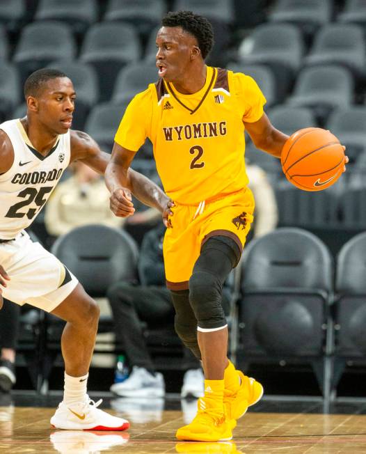 Wyoming guard A.J. Banks (2, right) looks to pass versus Colorado guard McKinley Wright IV (25) ...