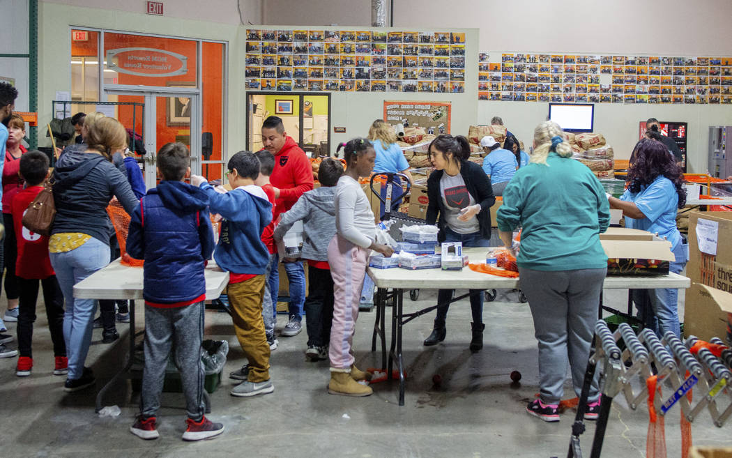 Volunteers and family members from Diamond Resorts and Las Vegas United Soccer Club pack fresh ...