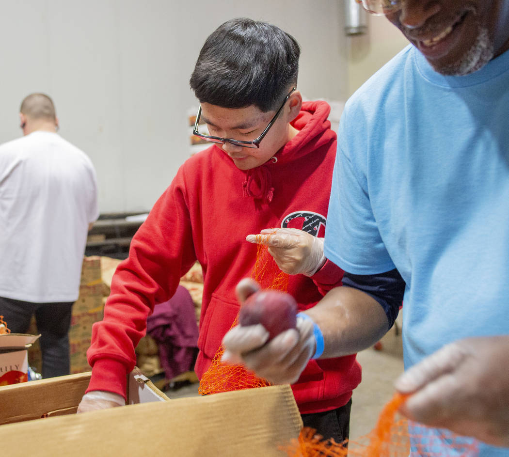 Kai Tran, 12, North Las Vegas, packs fresh produce with a volunteer team from Diamond Resorts a ...