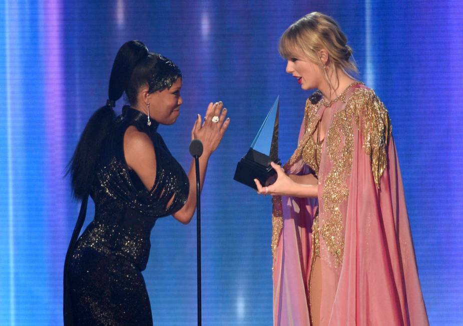 Regina King, left, presents the award for artist of the year to Taylor Swift at the American Mu ...