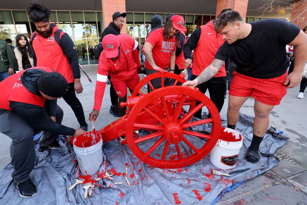 UNLV Football players paint the Fremont Cannon red during a celebration on campus Monday, Nov. ...