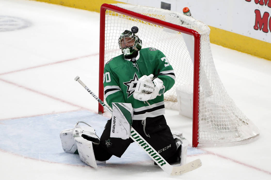 A shot from the Vegas Golden Knights hits off the front of the mask of Dallas Stars goaltender ...