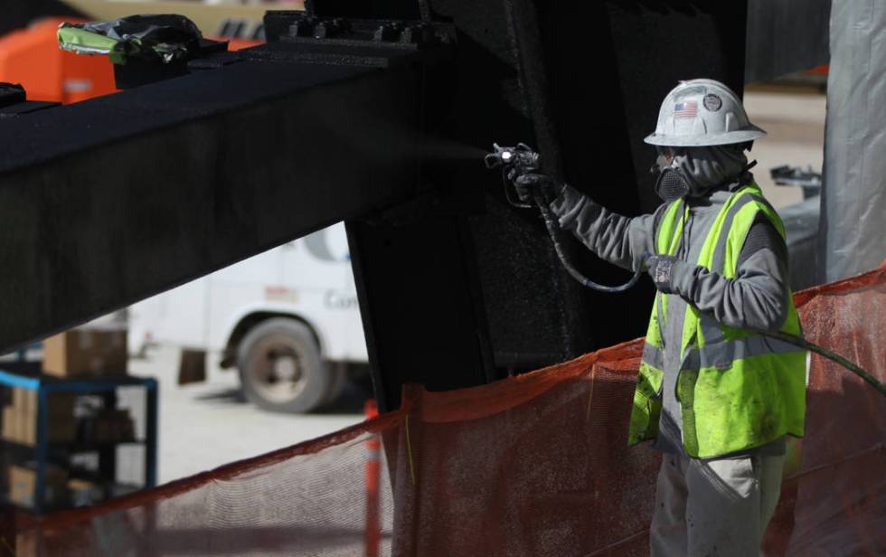 A worker paints a piece of structure of the Raiders Allegiant Stadium in Las Vegas, Monday, Nov ...