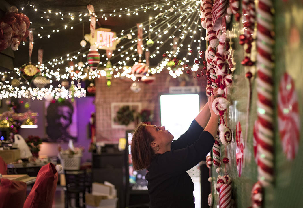 Sara Kiper decorates a wall at the Sand Dollar Lounge in Las Vegas, Monday, Nov. 25, 2019. The ...