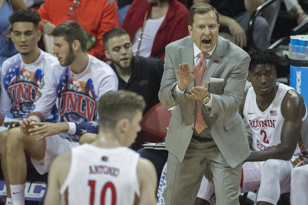 UNLV Rebels head coach T.J. Otzelberger, top/right, directs his team during their NCAA basketba ...