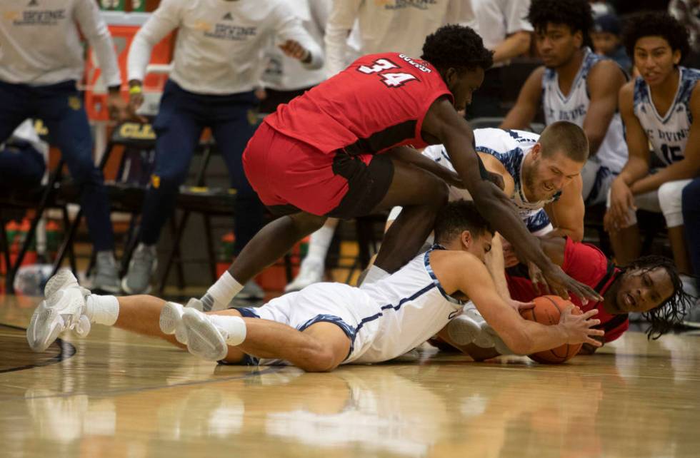 UC-Irvine's guard Isaiah Lee (5) and guard Devin Cole (1) dive for the ball with Louisiana's fo ...