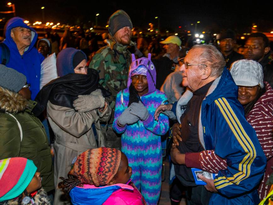 Father John McShane, right, receives a hug from behind as he offers prayers to those in need ga ...