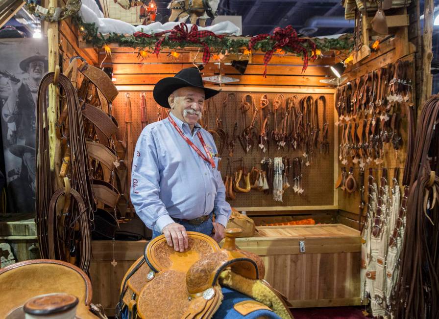 Tommy Conway stands by a group of his custom-made saddles at Cowboy Up Saddles during Cowboy Ch ...