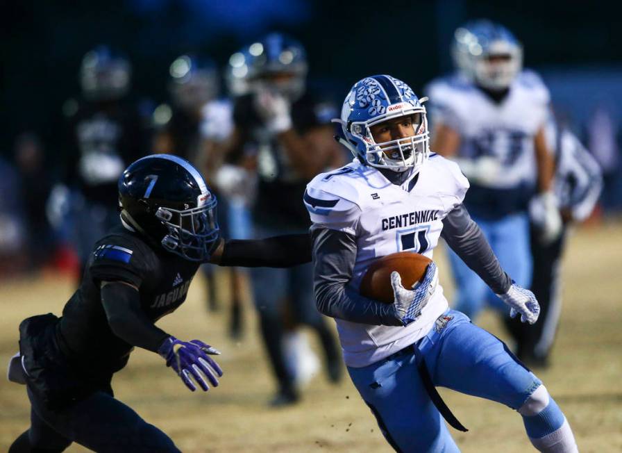 Centennial's Aaron Shields (7) runs the ball past Desert Pines' Darrien Stewart (7) during the ...