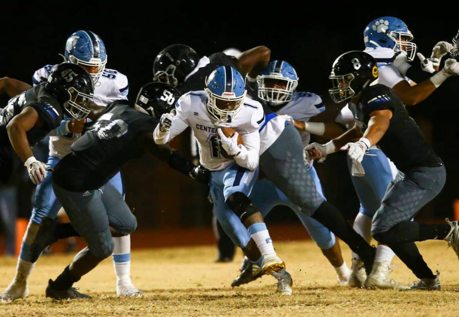 Centennial's Jordan Smith (1) runs the ball past Desert Pines' Elijah Wade (50) and Will Paden ...