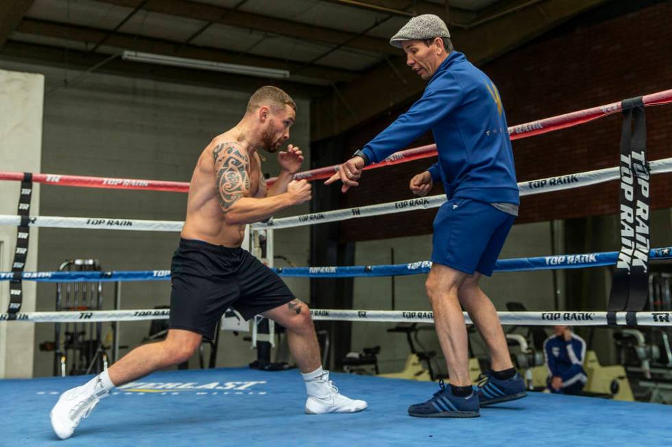 Former two-weight world boxing champion Carl Frampton, left, works on his footing with trainer ...