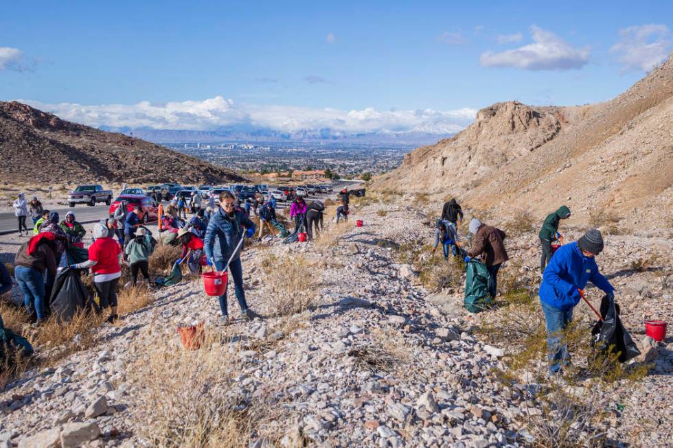 Volunteers for Get Outdoors Nevada clean up garbage near the trail leading to the Great Unconfo ...