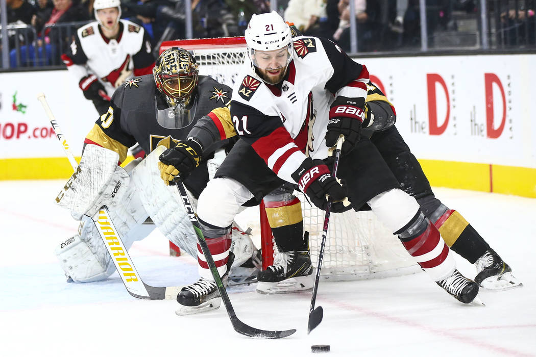 Arizona Coyotes' Derek Stepan (21) moves the puck as Golden Knights goaltender Malcolm Subban ( ...