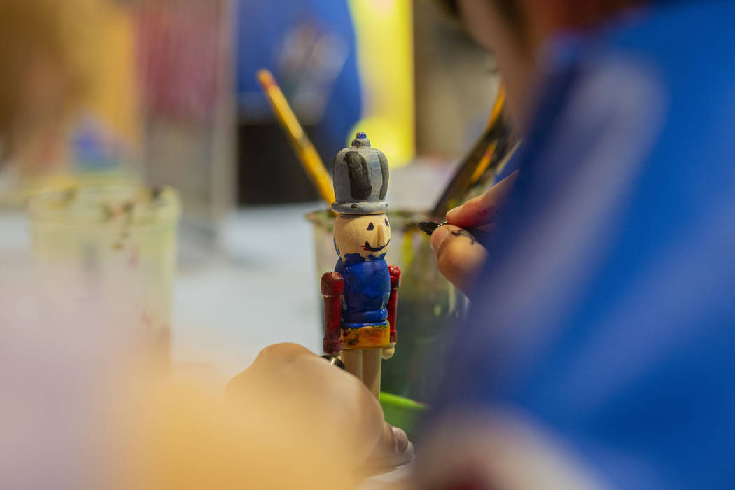 Harrison Taylor, 7, of Las Vegas, paints a nutcracker ornament during the Discovery Children's ...