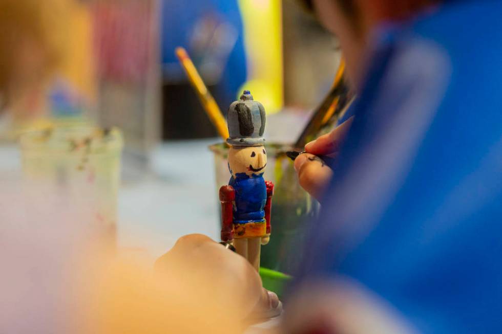 Harrison Taylor, 7, of Las Vegas, paints a nutcracker ornament during the Discovery Children's ...