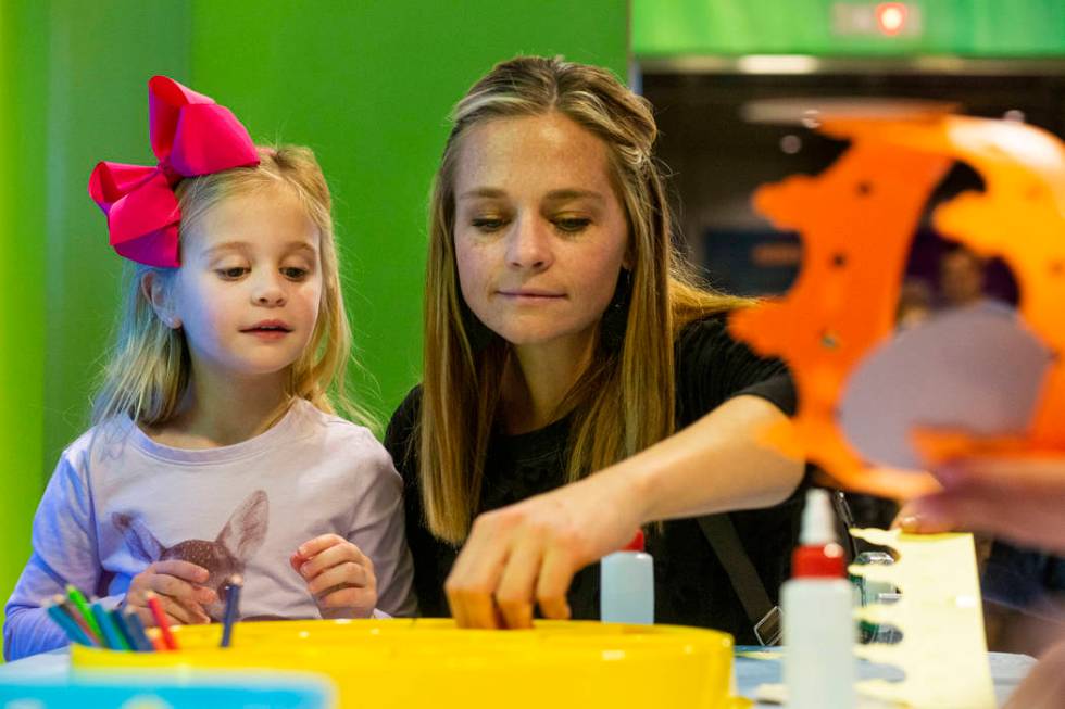 Addison Piraino, 5, left, and Sophia Piraino of Denver make craft crowns at the Discovery Child ...