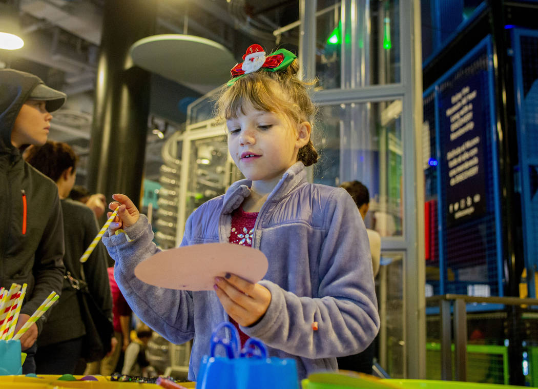 Vivienne Durkin, 8, of Las Vegas, makes a paper lollipop at a craft station during theʄis ...