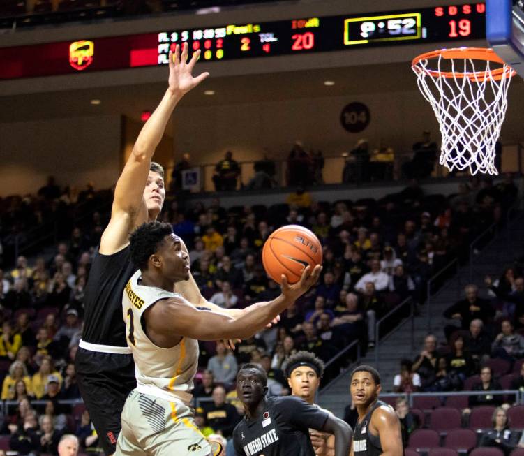 University of Iowa's Joe Toussaint (1) jumps to dunk the ball as SDSU's forward Yanni Wetzell, ...