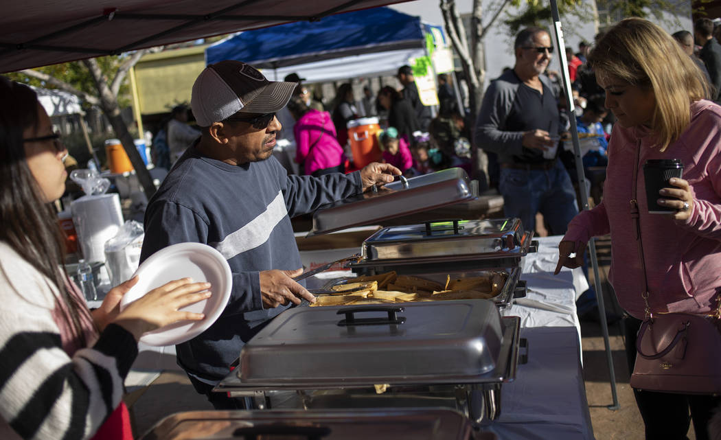 Rosie Lopez of Las Vegas, right, orders a traditional Oaxacan tamale from Pedro Sanchez, center ...