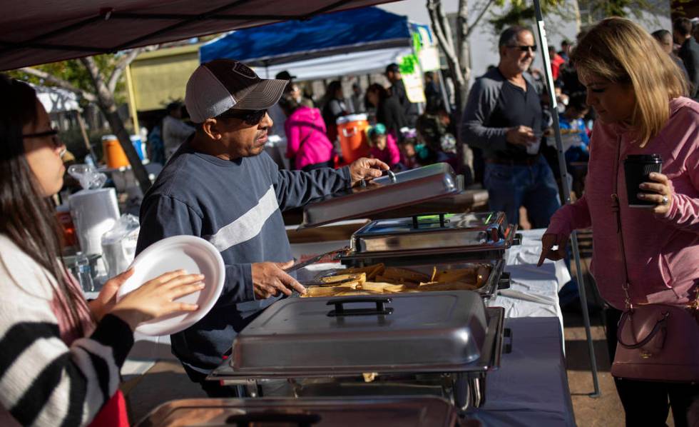 Rosie Lopez of Las Vegas, right, orders a traditional Oaxacan tamale from Pedro Sanchez, center ...