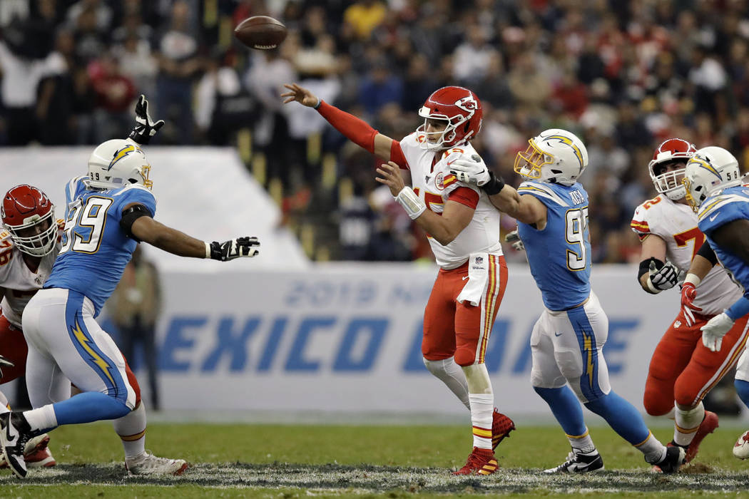 Kansas City Chiefs quarterback Patrick Mahomes throws a pass under pressure from Los Angeles Ch ...