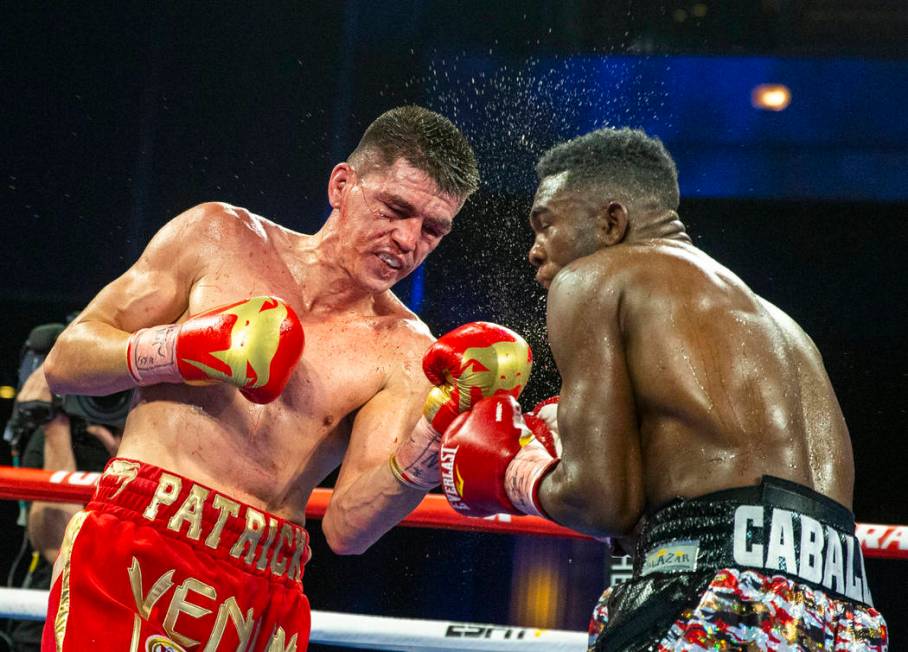 Patrick Teixeira, left, connects with the chin of Carlos Adames during round 8 in their super w ...